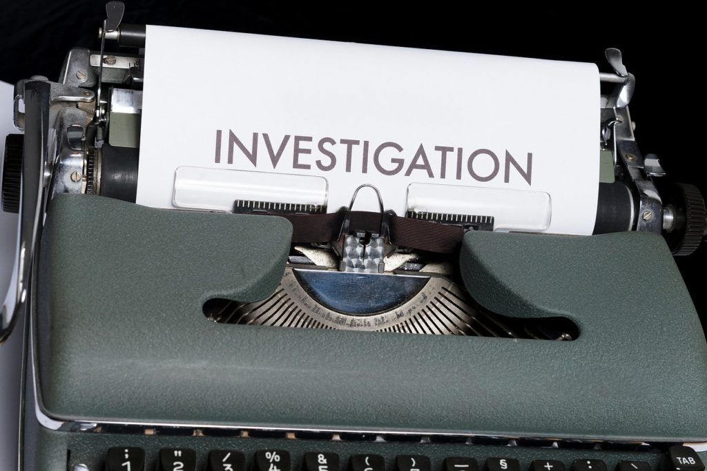 typewriter with paper in it that says investigation